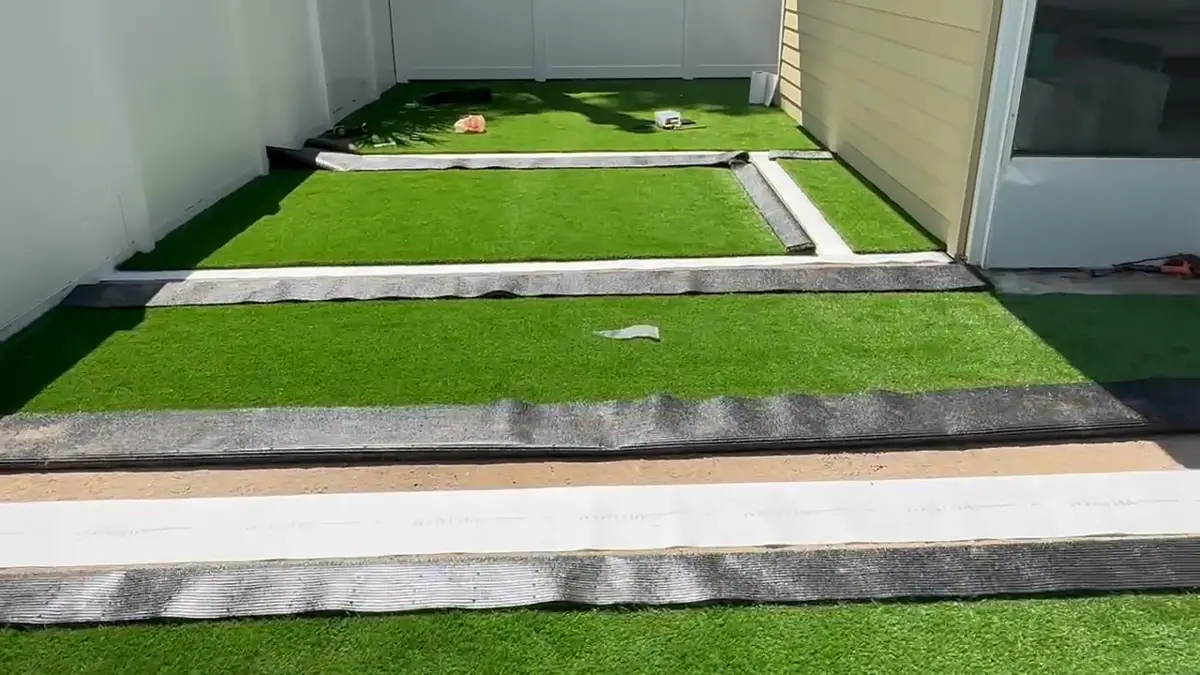 Artificial turf strips with a paver border during installation