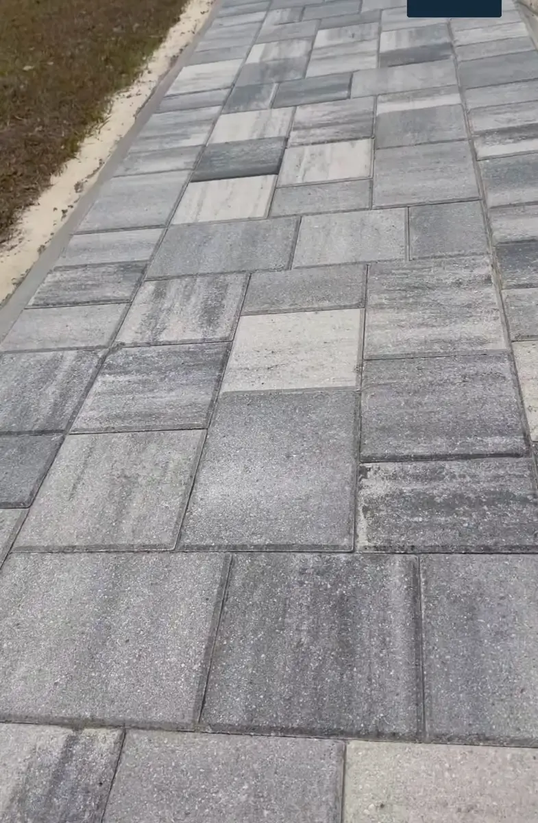 Long gray paver walkway along a home