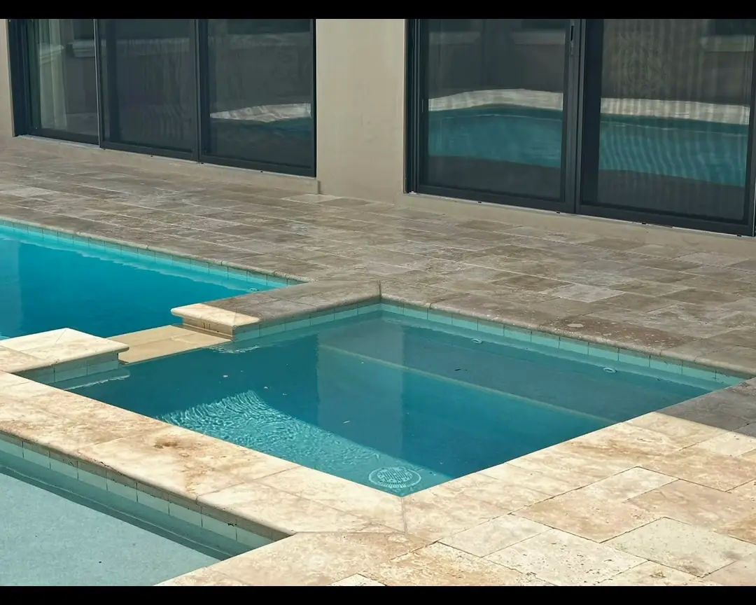 Light travertine paver pool deck at a modern home in Central Florida